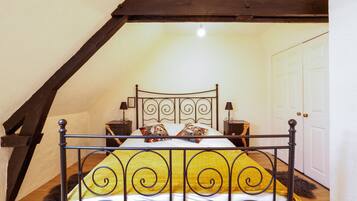 A bed with a metal frame, two bedside tables, and a white door in the background.