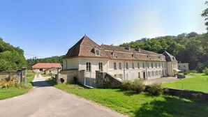 A large, multi-story building with a prominent central tower, a paved driveway, and a well-maintained lawn. - Bed and Breakfast 'Double' with Shared Terrace, Private Garden and Wi-Fi (Rollainville)