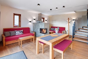 Ein modernes Interieur mit Kamin, Holzmöbeln und einer Treppe.