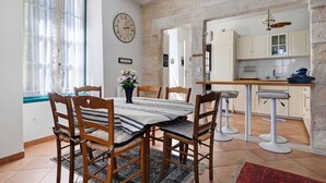 A dining area with a table, chairs, and a clock on the wall.