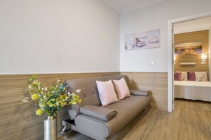 Una sala de estar moderna con un sofá, un florero y una pared de acento de madera.