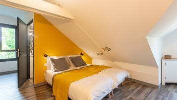 A bedroom with a bed, a wardrobe, and a window.