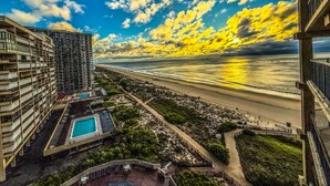 A high-rise hotel with a swimming pool, beach view, and a sunset. - Oceanfront l Pool l Elevator l Private Balcony with Sunrise views (Ocean City)