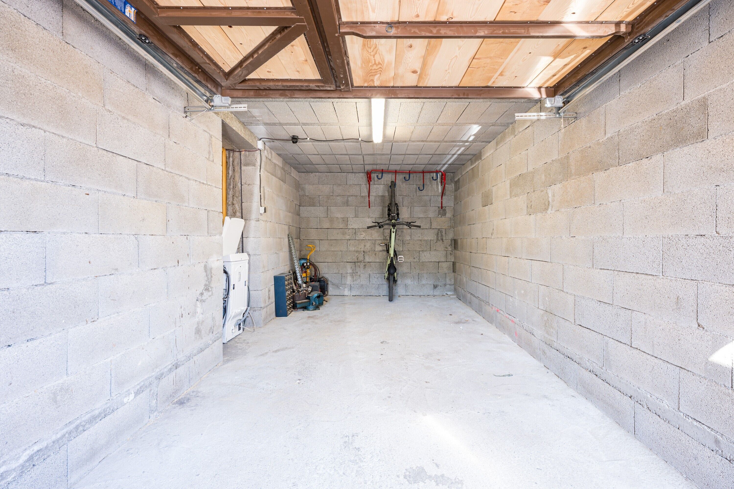 A room with concrete block walls, a wooden ceiling, and a central bike rack.