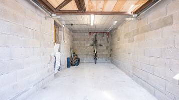 A room with concrete block walls, a wooden ceiling, and a central bike rack.