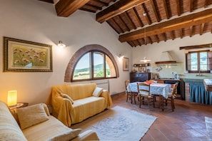 Una habitación acogedora con sofá, una mesa de comedor y una zona de cocina.