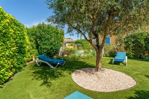 A well-maintained garden with two lounge chairs, a tree, and a circular gravel area. - Holiday Home “L'Olivier” with Shared Pool, Wi-Fi & Air Conditioning (L'Isle-sur-la-Sorgue)