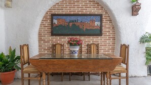 Een eettafel met stoelen, een mozaïekkunstwerk en een potplant.
