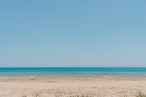 A beach with a clear sky and calm sea.