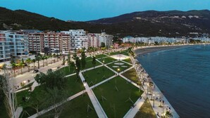 A coastal urban area with modern buildings, a well-maintained public square, and a beach. - Spacious Sea View Apartment Private Balcony · Steps to Beach · Vlora Albania (Vlore)