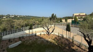 A fenced outdoor area with a clear view of a hilly landscape and buildings in the background. - Modern studio - terrace - pool (Villeneuve-Loubet)