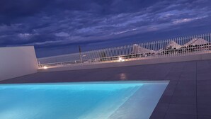 A swimming pool with a white fence and a view of buildings in the background. - Modern studio - terrace - pool (Villeneuve-Loubet)