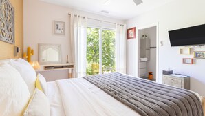 A bedroom with a bed, a desk, a chair, a television, and a bathroom visible through an open door. - Guest Room 'Esprit Du Soleil' with Shared Pool, Wi-Fi, and Air Conditioning (Perpignan)