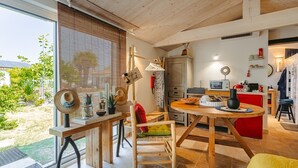 Een moderne keuken met houten kastjes, een eettafel en uitzicht op de omgeving.