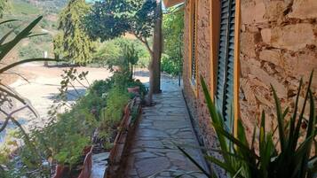 Un camí de pedra que condueix a un edifici amb una paret de pedra rústica i una porta de fusta.
