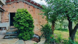 Un edificio rustico con facciata in pietra, una porta in legno e un piccolo portico.