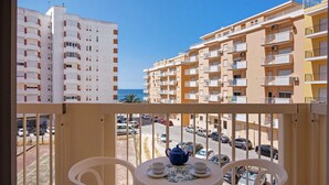 A balcony with a table, chairs, and a teapot. - Colmeia AL - Casa Néctar (Armação de Pêra)