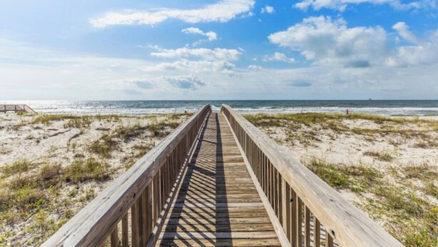 A wooden boardwalk leading to a beach with a clear sky. - 4 Bedroom Pet Friendly House in Fort Morgan - Free Daily Activities! (Gulf Shores)