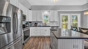 A modern kitchen with stainless steel appliances, white cabinetry, and a large island. - 4 Bedroom Pet Friendly House in Fort Morgan - Free Daily Activities! (Gulf Shores)