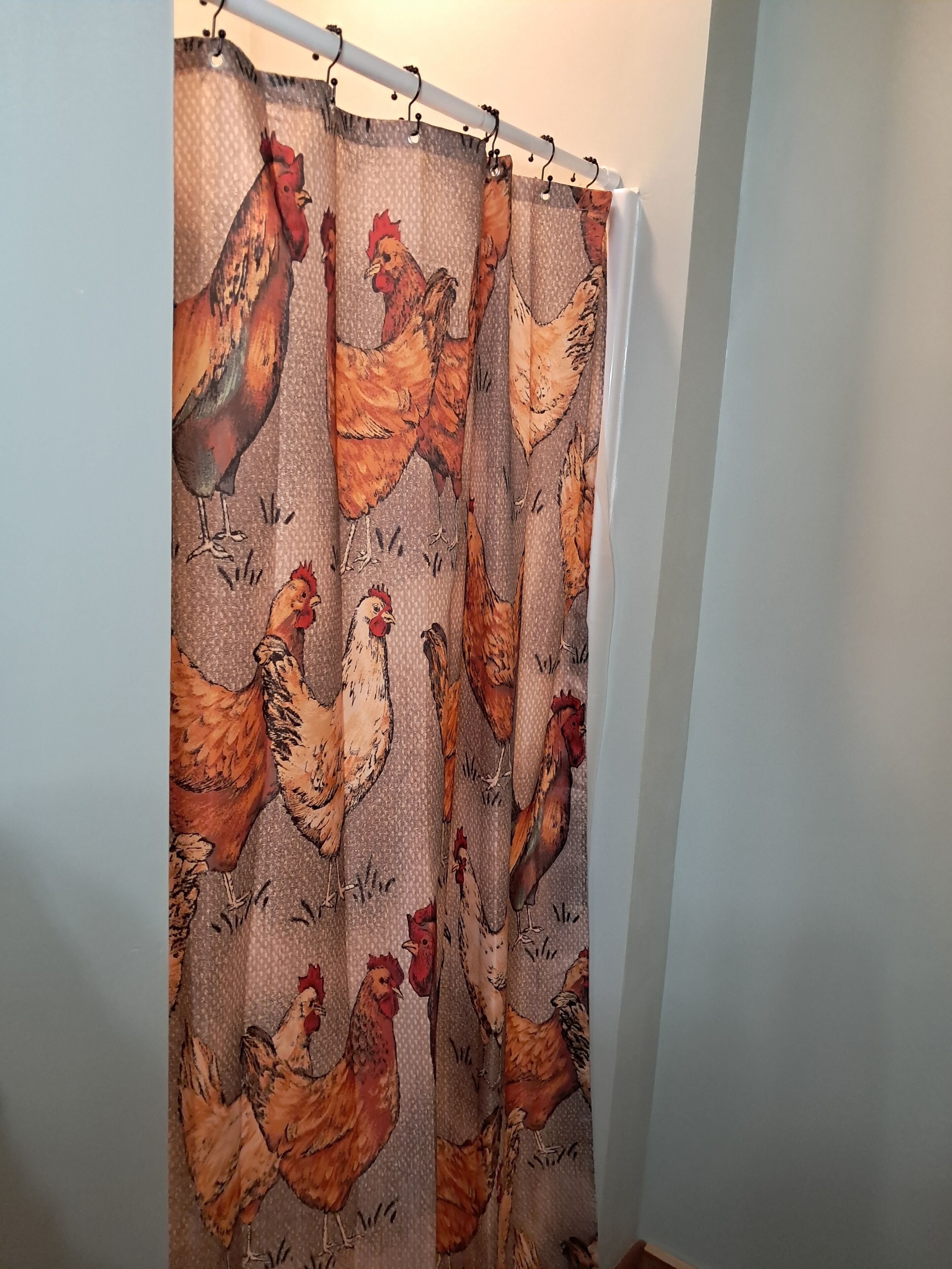 Cortina de ducha con estampado de gallo.