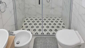 A modern bathroom with a glass-enclosed shower, a bidet, and a toilet. - Apartmentcomplete with kitchen and personal bathroom located downtown (Bari)