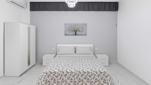 A bedroom with a bed, a nightstand, a wardrobe, and a wall-mounted air conditioner. - Apartmentcomplete with kitchen and personal bathroom located downtown (Bari)