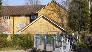 A residential building with a sloped roof and a balcony.