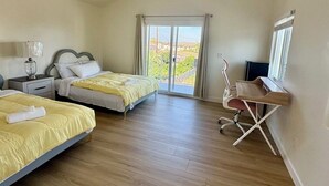 Una habitación de hotel con dos camas, un escritorio y una silla.