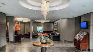A modern lobby with a round table, seating area, and a television. - Westwinds - Funky Basecamp in the Rockies (Canmore)