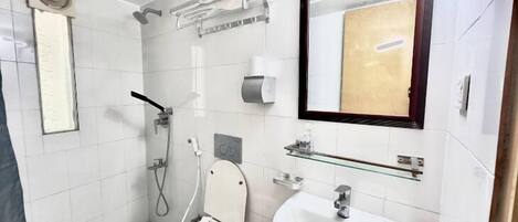 Une salle de bain moderne équipée de toilettes, d’un lavabo et d’une douche.