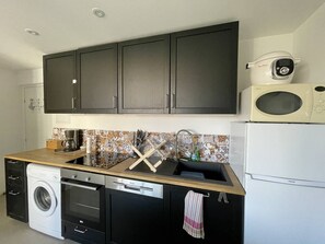 Réfrigérateur, four, batterie de cuisine, vaisselle et ustensiles