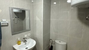 A bathroom with a sink, mirror, toilet, and a shower enclosure. - Peaceful retirement near the station (Marrakech)