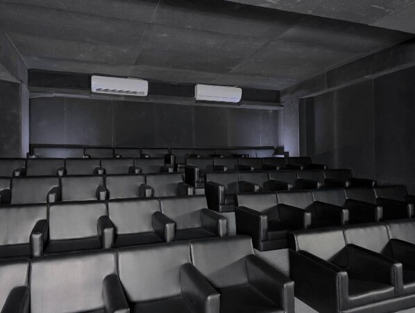 A cinema with rows of black seats and two air conditioning units on the ceiling. - 330sqft 3 Modern Stay with Sauna Pool (Dhaka)