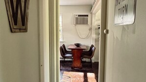 A hallway with a dining area in the background, a 'NO RIGHT TURN' sign, and a large 'W' sign on the wall. - Chic Dunes Cottage W/ HOT TUB near Warren Dunes / Lake MI! (Shorewood-Tower Hills-Harbert)