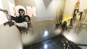 A corridor with a mural of a cityscape and a person holding a gun. - Yeongdeungpo Station New York Hotel (Seoul)