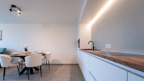 A modern kitchen with a wooden countertop, white cabinets, and a built-in sink. - Elyana with balcony by Interhome (Blankenberge)