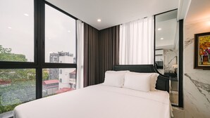 Ein modernes Hotelzimmer mit einem großen Bett, Blick auf die Stadt und einer Marmorwand.