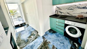 A narrow hallway with a washing machine and teal cabinets. - Luxury penthouse with sea views (Benidorm)