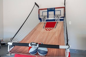 Ein Basketballkorb mit einer roten und blauen Rückwand, einem Holzboden und einem roten Teppich.