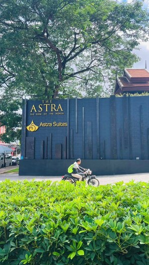 A sign for 'The Astra The Gem of the North' with a modern building in the background.