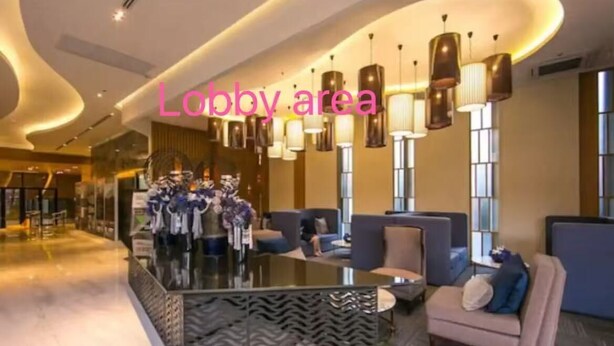 A lobby area with seating arrangements, a reception desk, and modern lighting fixtures.
