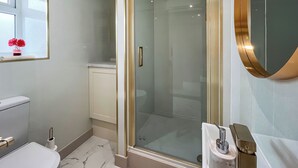 Une salle de bain moderne avec une douche à parois de verre, des toilettes et un lavabo.