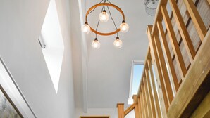 A staircase with wooden railings and a ceiling light fixture with four bulbs. - Roseland Retreat - UK49838 (Truro)