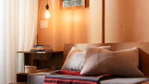 Een gezellige kamer met een bank, een nachtkastje met boeken, een lamp en een bordje dat aangeeft dat het deel uitmaakt van Mount Rainier National Park.