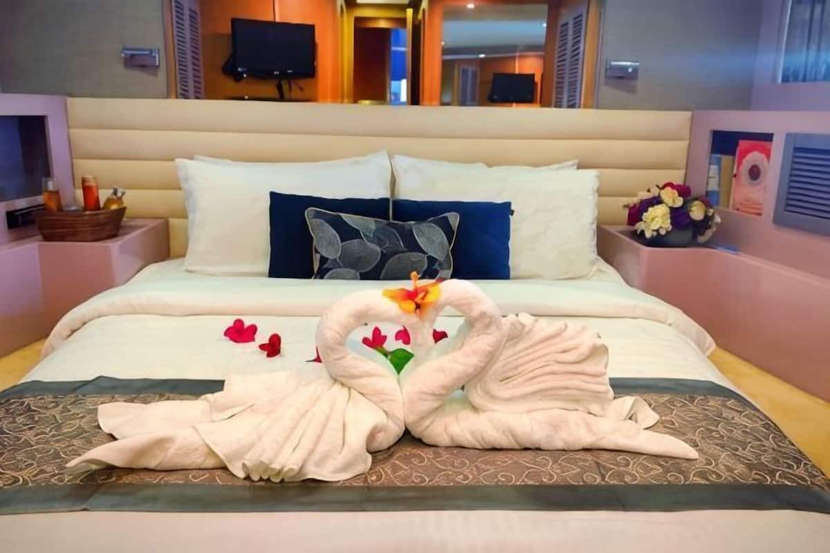 Ein Hotelzimmer mit einem großen Bett, einem Kopfteil, einem Flachbildfernseher und einem an der Wand befestigten Fernseher.