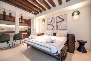A modern bedroom with a bed, bedside tables, and artwork on the wall.