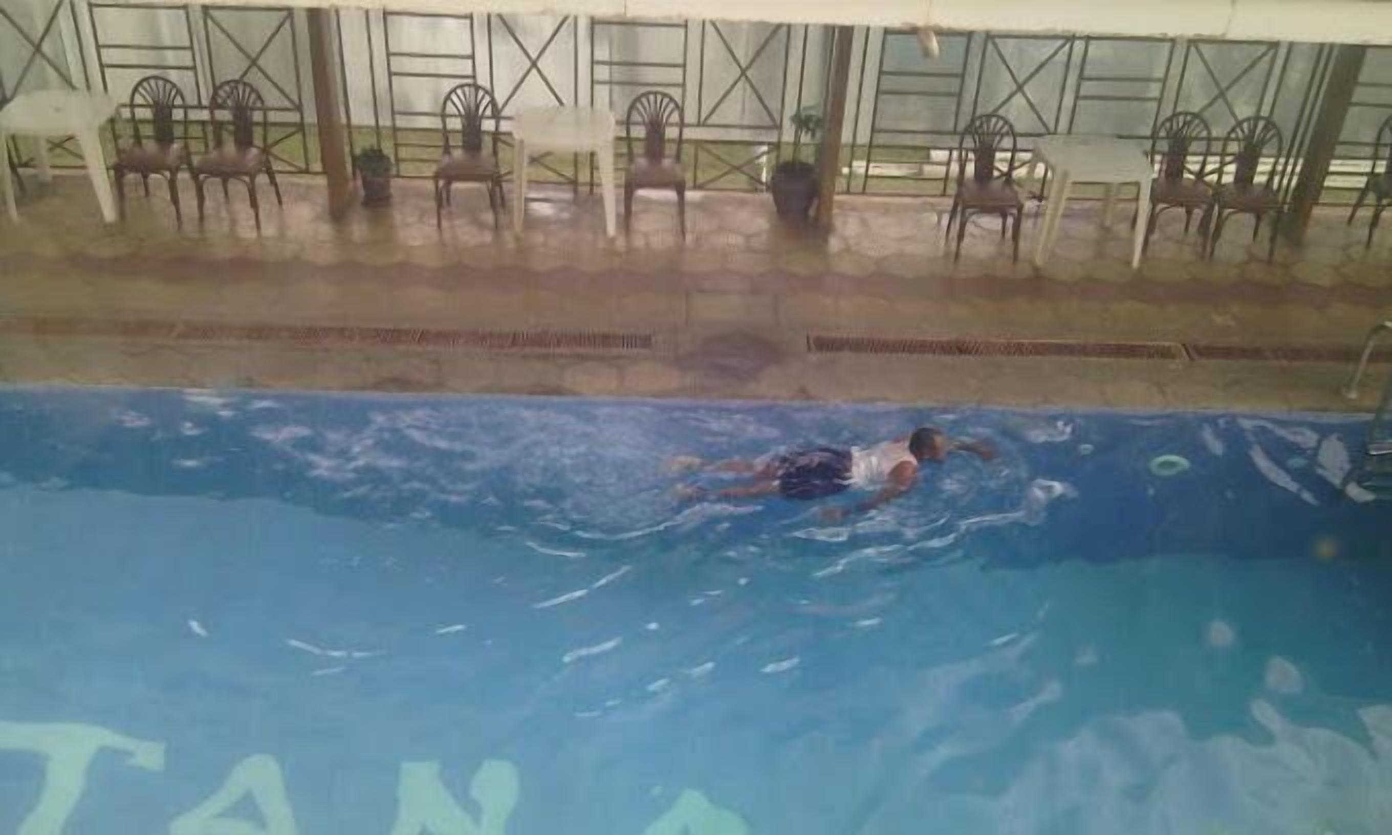 Une piscine dans laquelle une personne nage.
