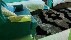 Ein Hotelzimmer mit zwei Betten, einem Sofa und einem gemusterten Teppich.