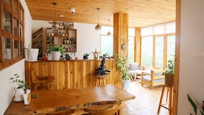 Een houten interieur met een bar, zitplaatsen en grote ramen.