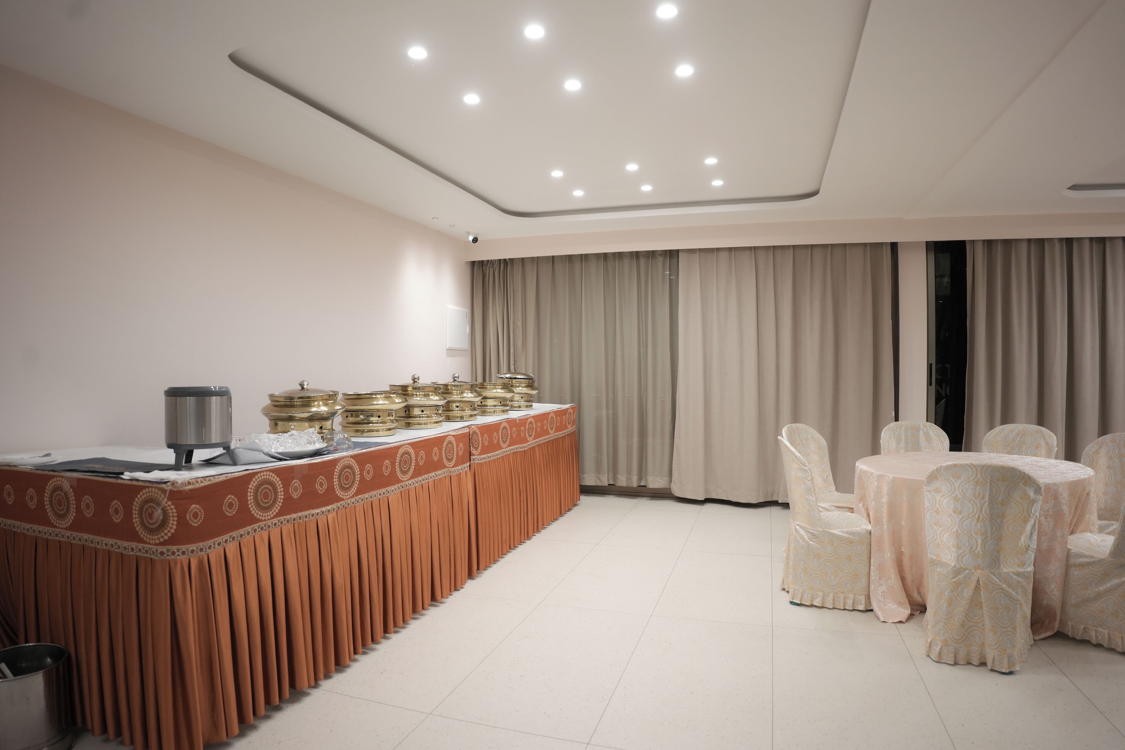 A conference room with a long table, chairs, and a buffet setup.